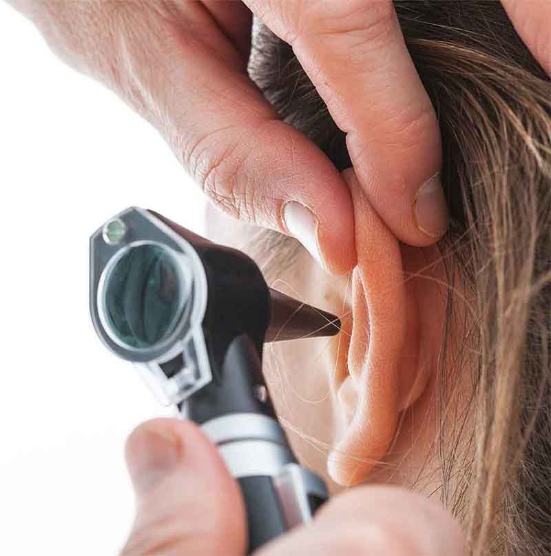 Close up of a person having their ear examined to check for hearing loss.